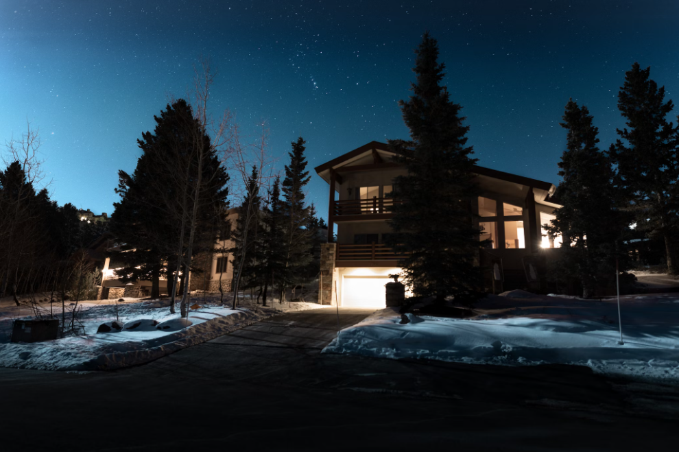 Home on street in darkness in snow.