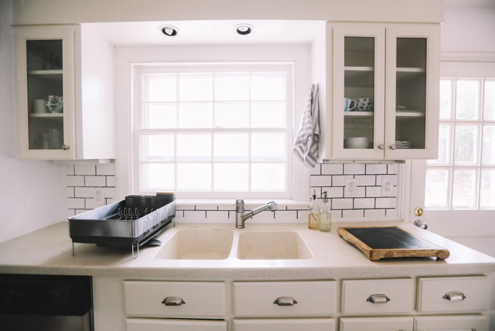 White kitchen with white subway tiles as backsplash.